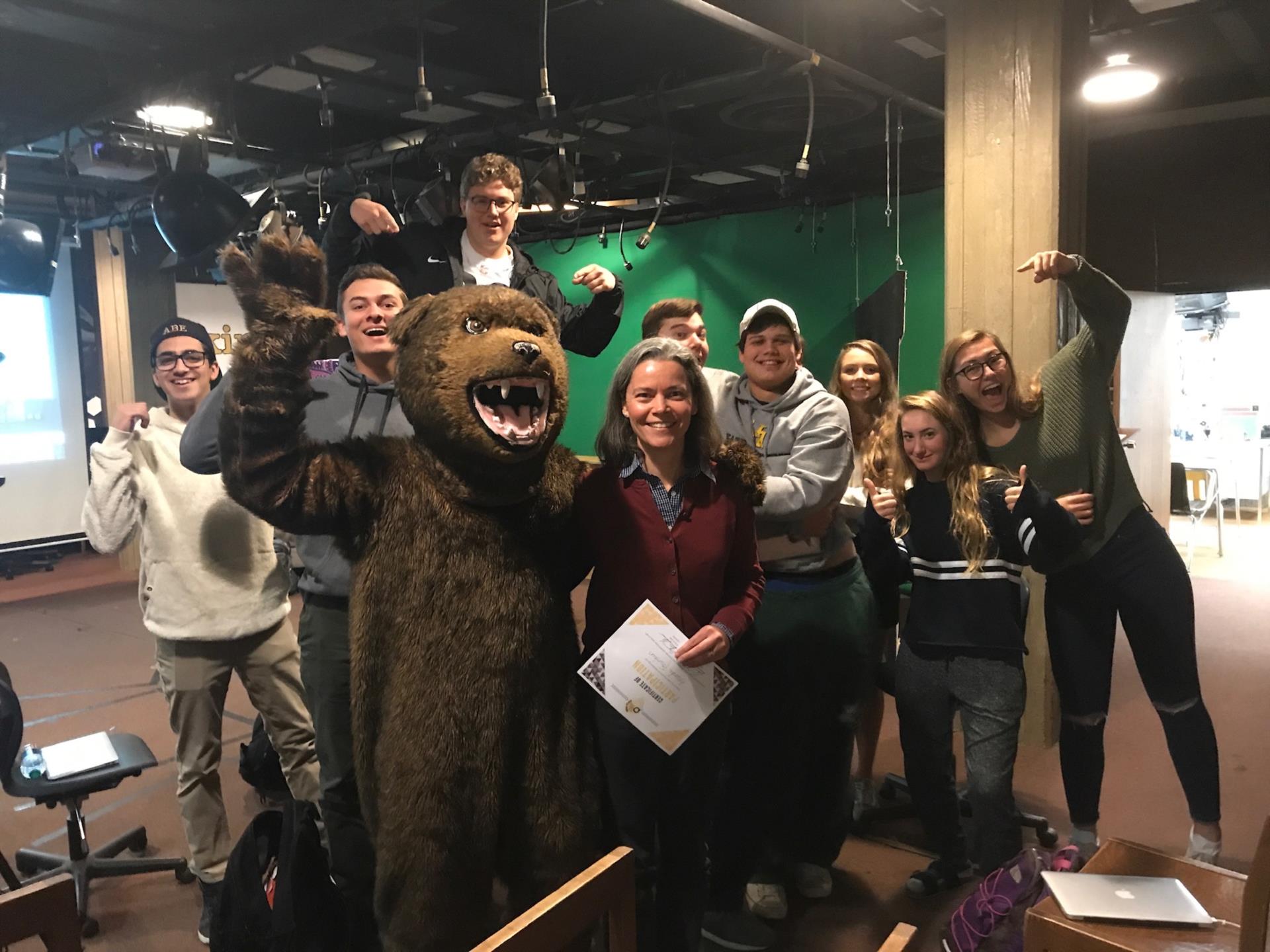 Students celebrating with a teacher and the bear mascot for Idea Hunt